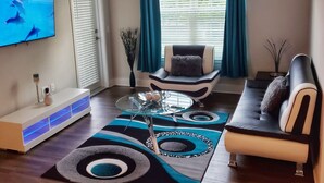 Un salon moderne avec un canapé, un fauteuil et une table basse.