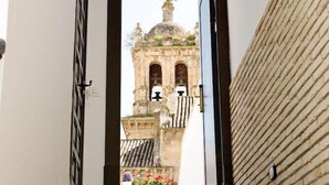 A staircase leading to a door with a view of a historic building with a bell tower. - Suites La Posada de Pilar (Córdoba)