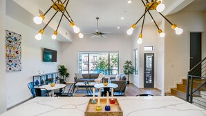 A modern living room with a marble dining table, a ceiling fan, and a staircase. - Buffalo Heights (Houston)