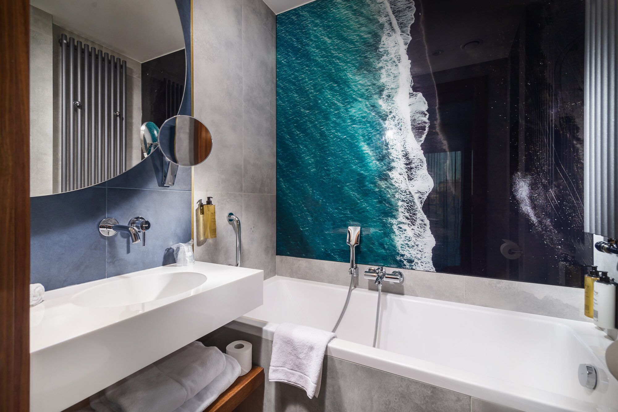 Un baño moderno con dos lavamanos, una bañera y un espejo grande.