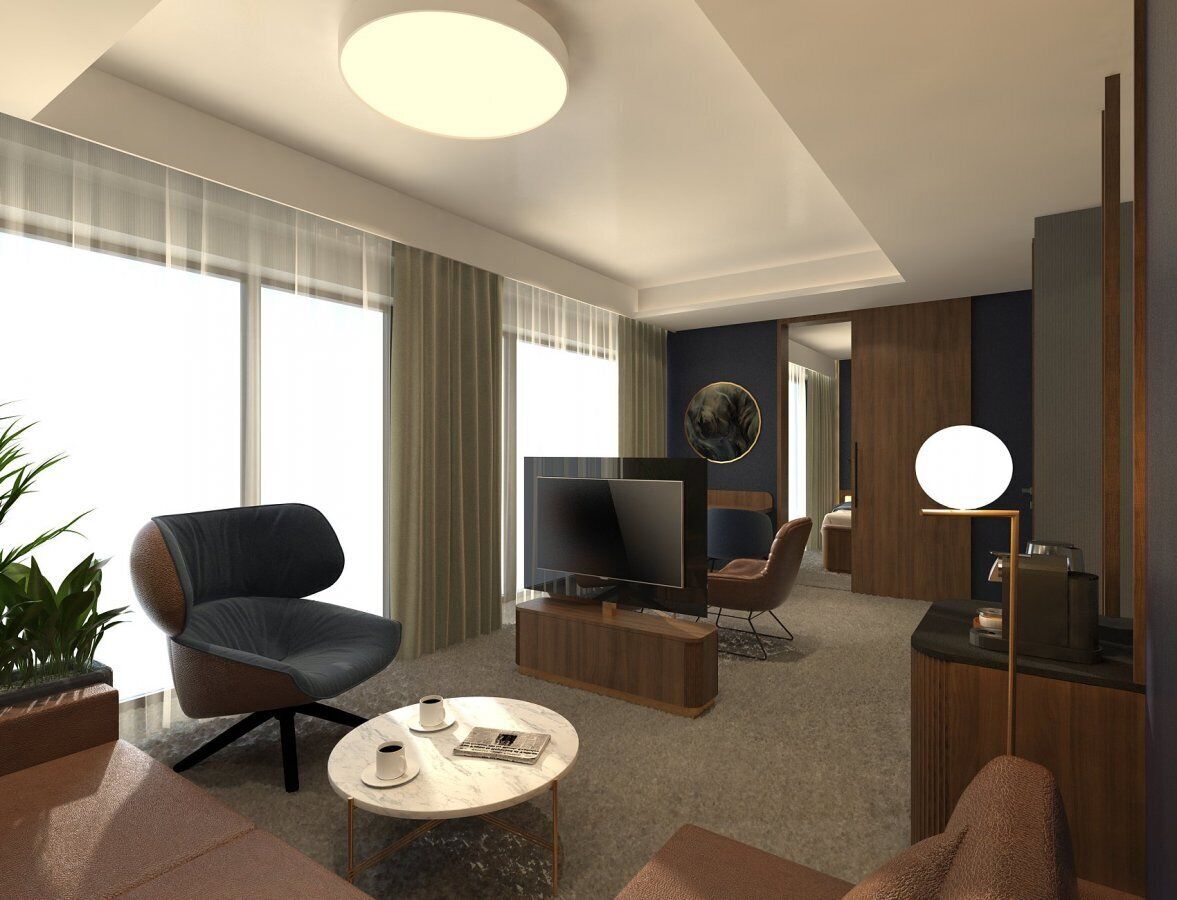 A modern hotel room with a large window, a flat-screen TV, a seating area with a sofa and armchairs, a coffee table, and a side table with a lamp.