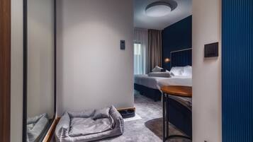 A hotel room with a bed, a desk, and a seating area.