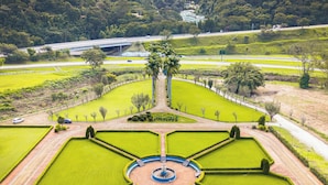 A landscaped garden with a central fountain, surrounded by manicured lawns and pathways. - Villa Itaipava Resort & Conventions (Petrópolis)