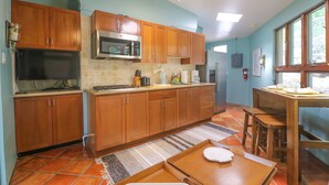 A kitchen with wooden cabinets, a microwave, and a refrigerator.