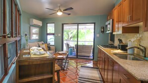 A kitchen with wooden cabinets, a microwave, and a sink.