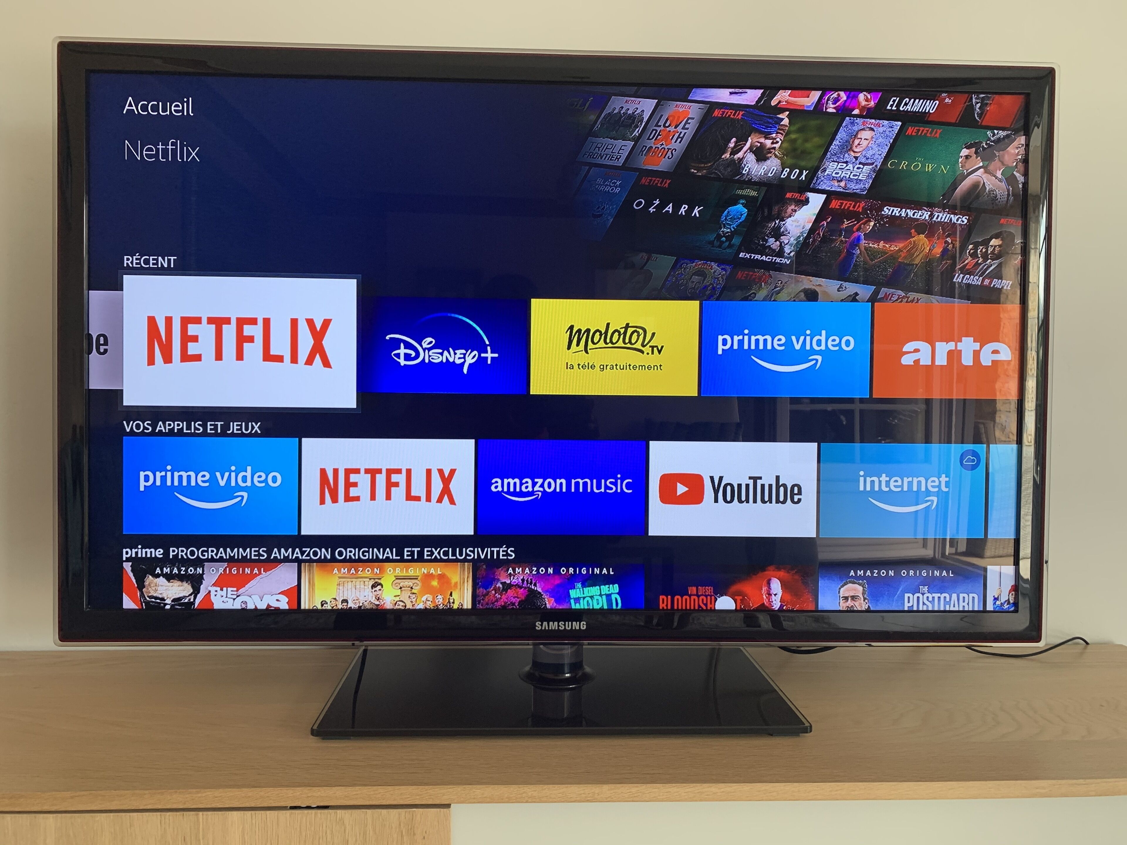 Un écran de télévision affiche l’interface d’un service de diffusion en continu, avec plusieurs icônes d’applications, notamment Netflix, Disney+ et Amazon Prime Video.