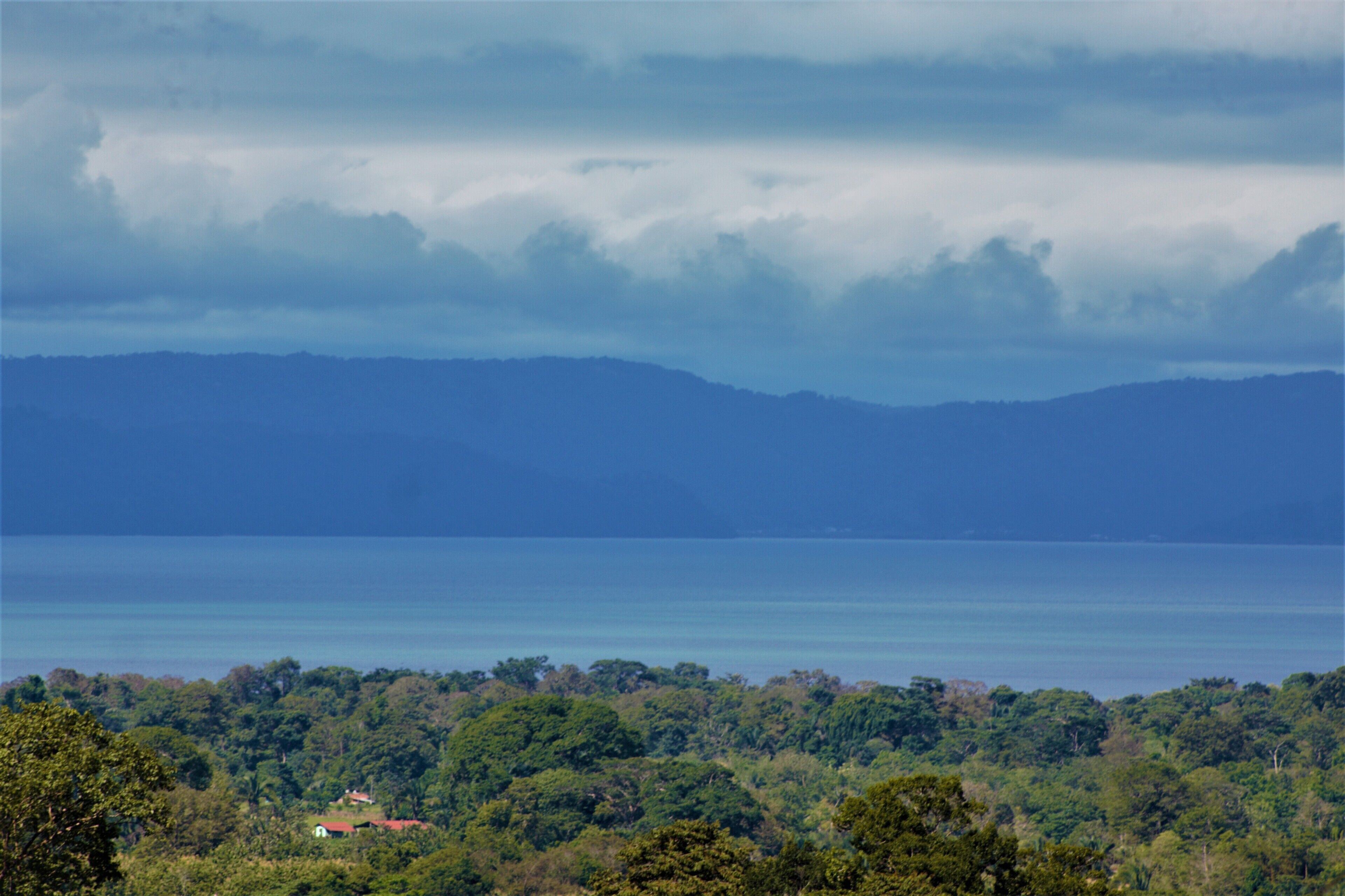 Eine Küstenlandschaft mit Blick auf das Meer und ferne Berge.