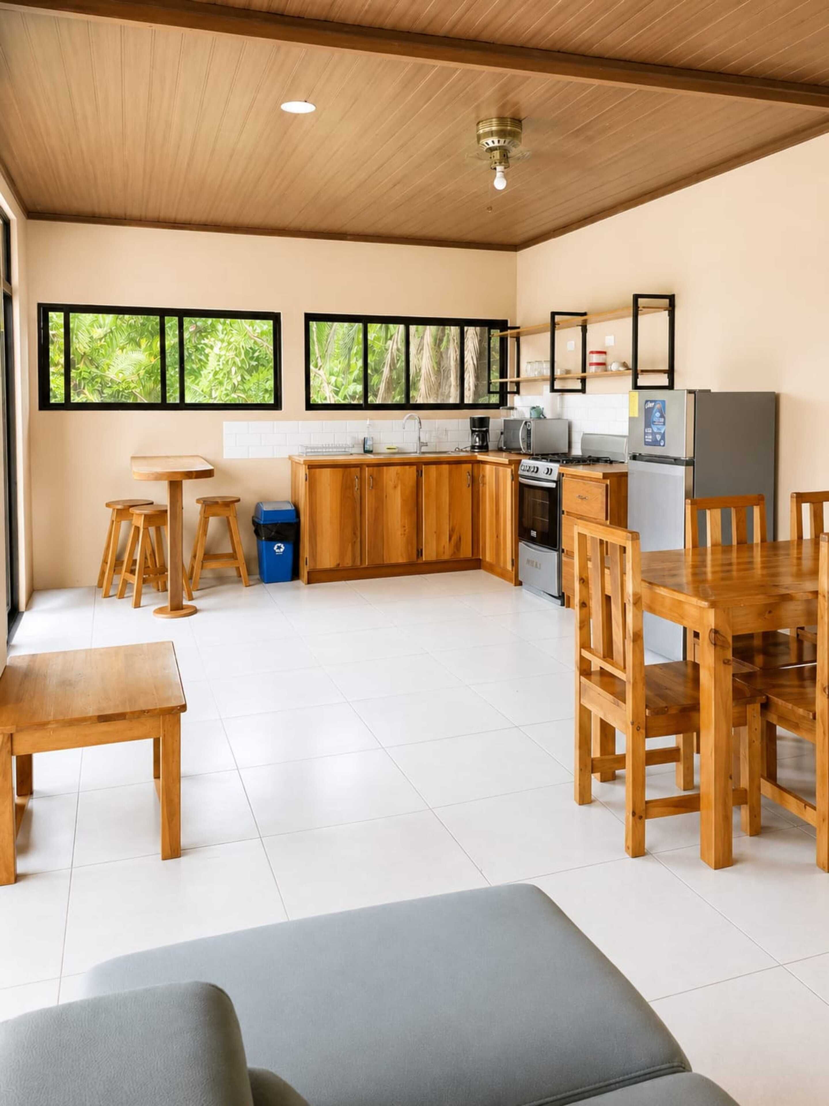 A spacious kitchen with wooden cabinets, a dining table, and a built-in oven.