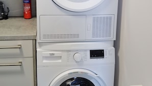 Een voorlader wasmachine met bedieningspaneel en zeepdosering.