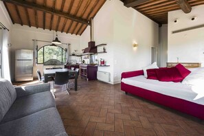 Een kamer met een bed, een bank, een eethoek en een keuken.