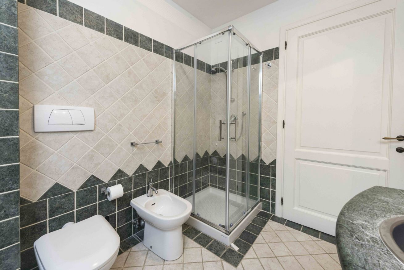 Ein Badezimmer mit Toilette, Bidet und einer Duschkabine.