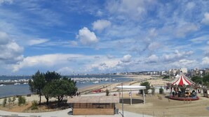 Vista costera con playa, un carrusel y un edificio que dice "LA STATION GLACIER".