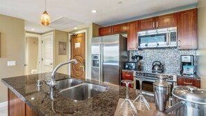 A modern kitchen with granite countertops, stainless steel appliances, and wooden cabinets.