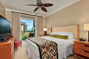 Quarto de hotel com cama, televisão, escrivaninha e varanda com vista para um edifício.