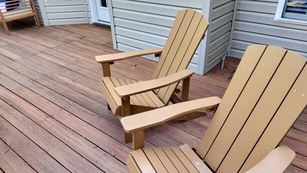 A wooden deck with two Adirondack chairs and a small table. - The Great Adventure (McGaheysville)