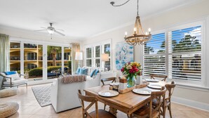 A spacious living area with a dining table, chairs, and a ceiling fan. - Beautiful, FABULOUS Ground Floor Corner Unit @ Adagio E105 (Santa Rosa Beach)