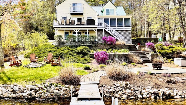 A two-story house with a balcony, a deck, and a small stream in front. - Come relax and play! Gameroom, kayaks, paddleboards, fire pit, screen porch (Barnstead)
