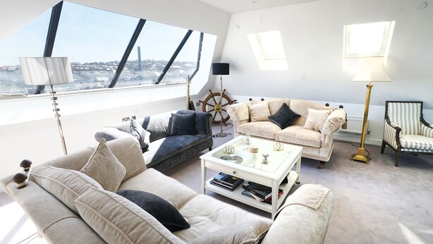 Un salon moderne avec une grande fenêtre, un canapé, une table basse et une lampe.