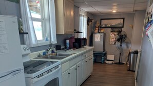 A kitchen with white appliances, a sink, and a microwave. - What a view of our beautiful Lake Jordan. This cabin is sure to charm you .  (Titus)