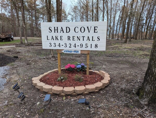 Shad Cove Lake Rentals -vuokrauskohteiden opaste, jossa on yhteystiedot ja Airbnb-VRBO-logo.