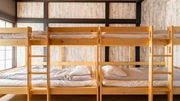 Dormitorio con literas de madera y ropa de cama blanca.