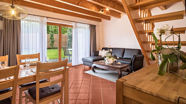 Un intérieur en bois comprenant un coin repas, un canapé et un escalier.