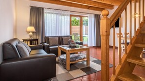 Una sala de estar con un sofá, una mesa de centro y una escalera.