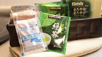 Un plateau contenant divers produits alimentaires emballés, notamment du thé vert Kirkland, un mélange de café Kirkland et un sachet de préparation pour soupe miso.