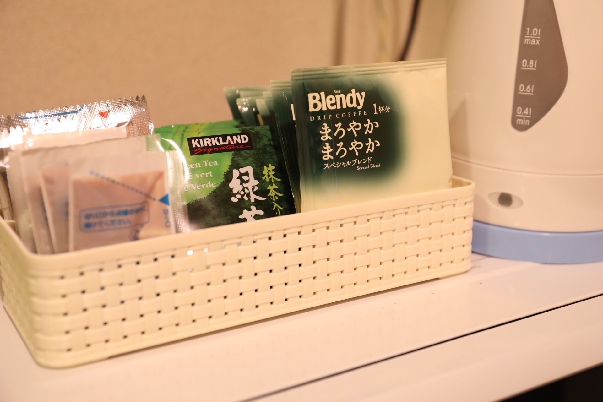 A tray with various coffee pods and a drip coffee maker on a table.