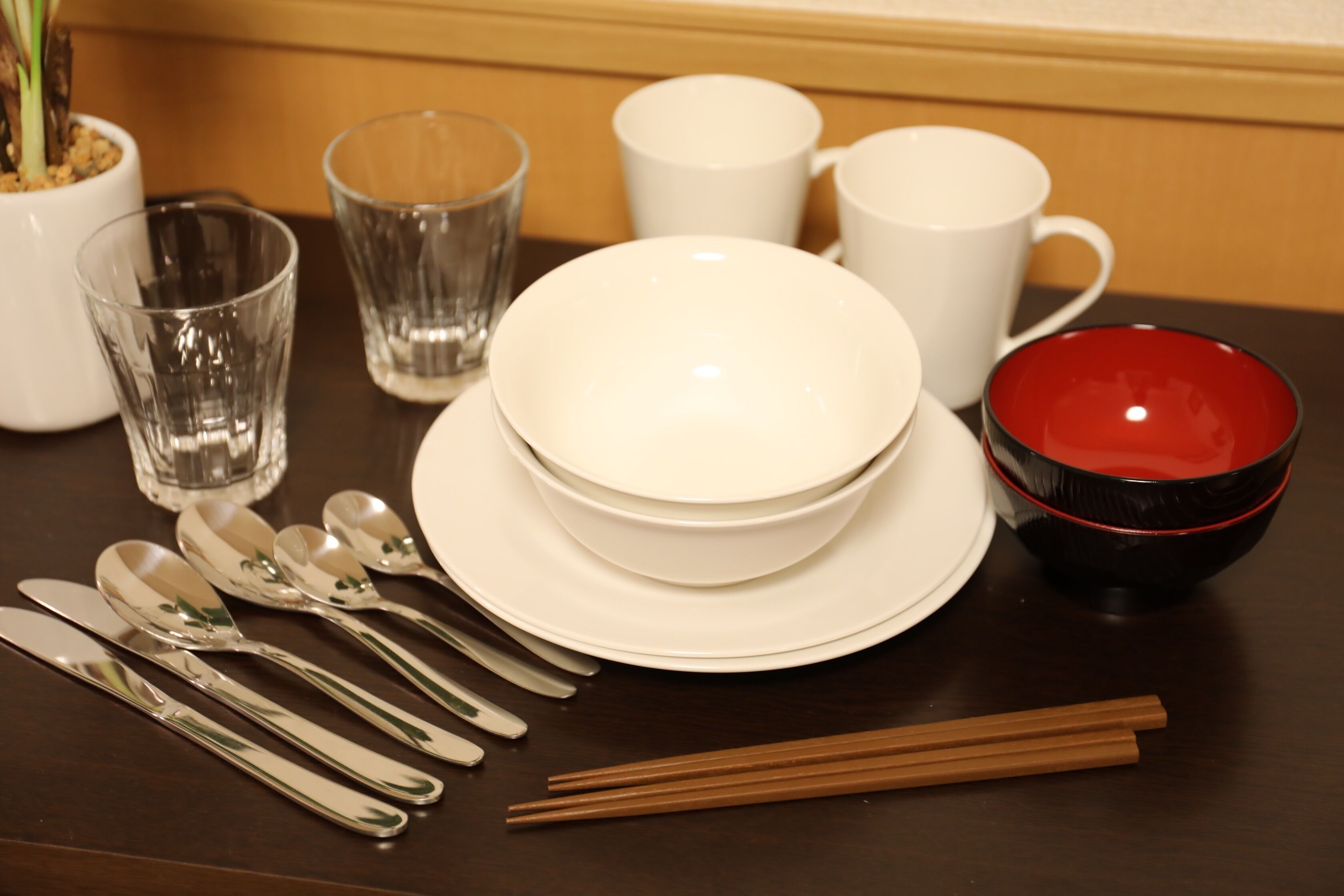 Una mesa de comedor con platos, tazones y cubiertos blancos.