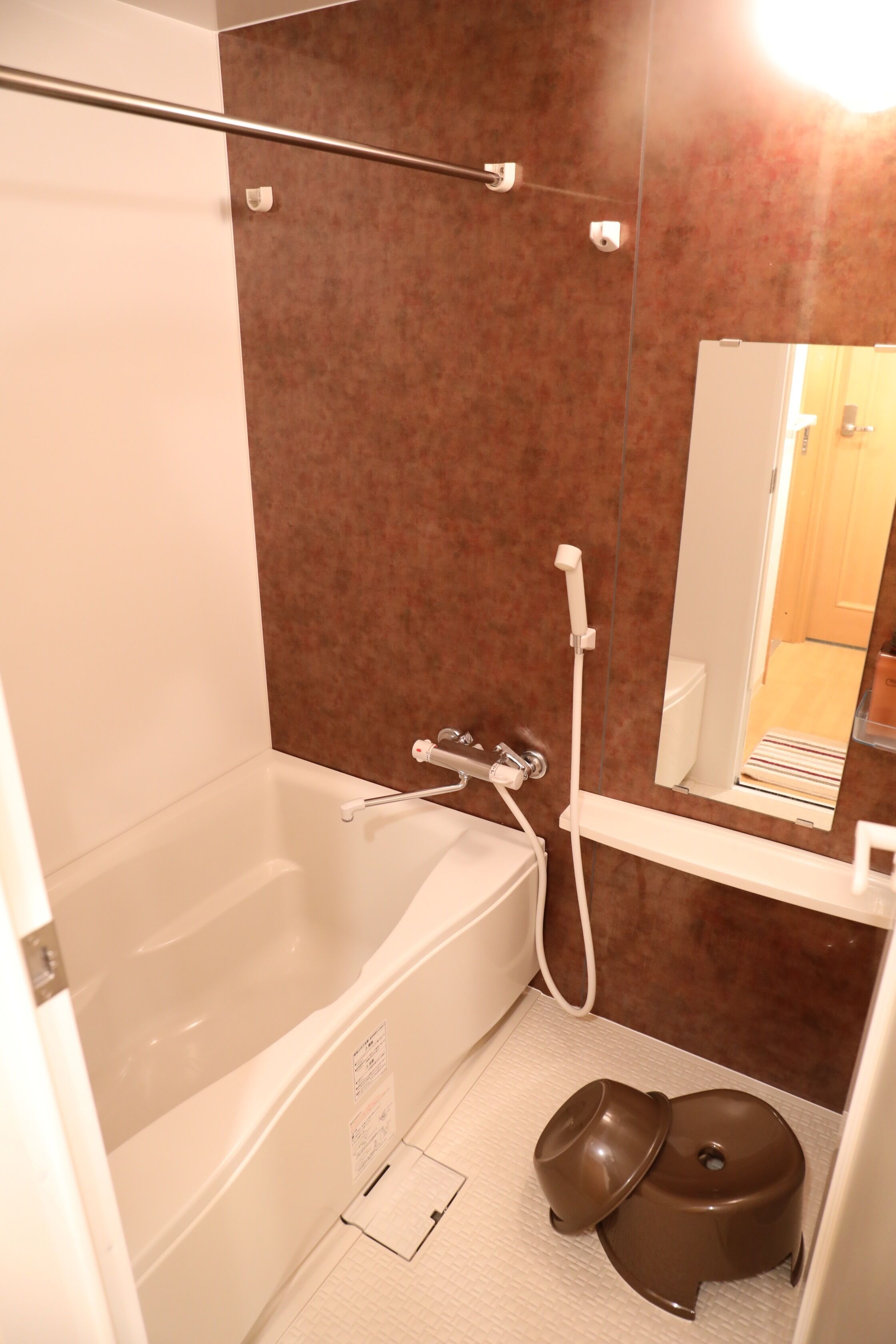 A bathroom with a bathtub, a shower, a toilet, and a mirror.