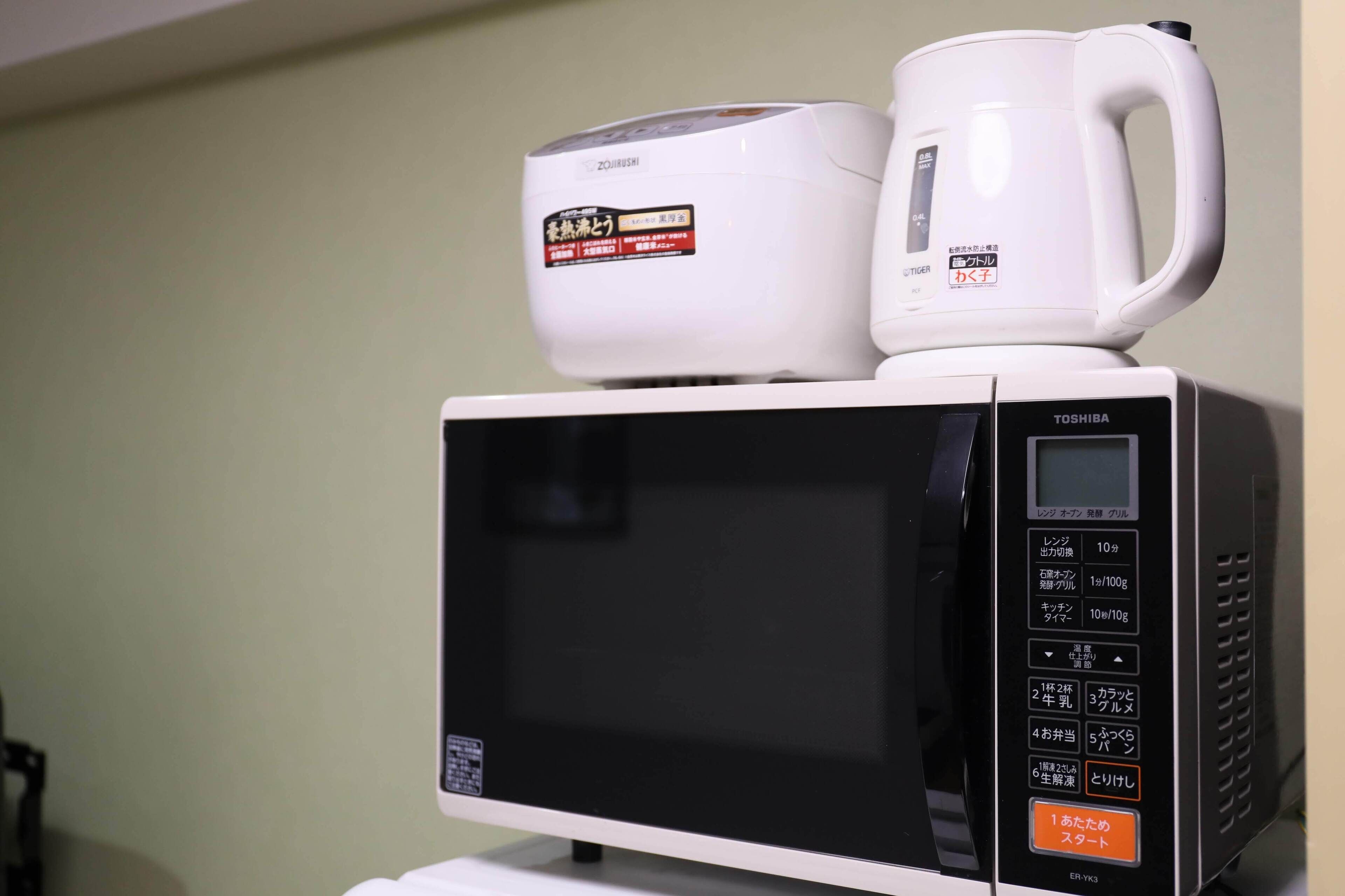A microwave with a coffee maker on top.