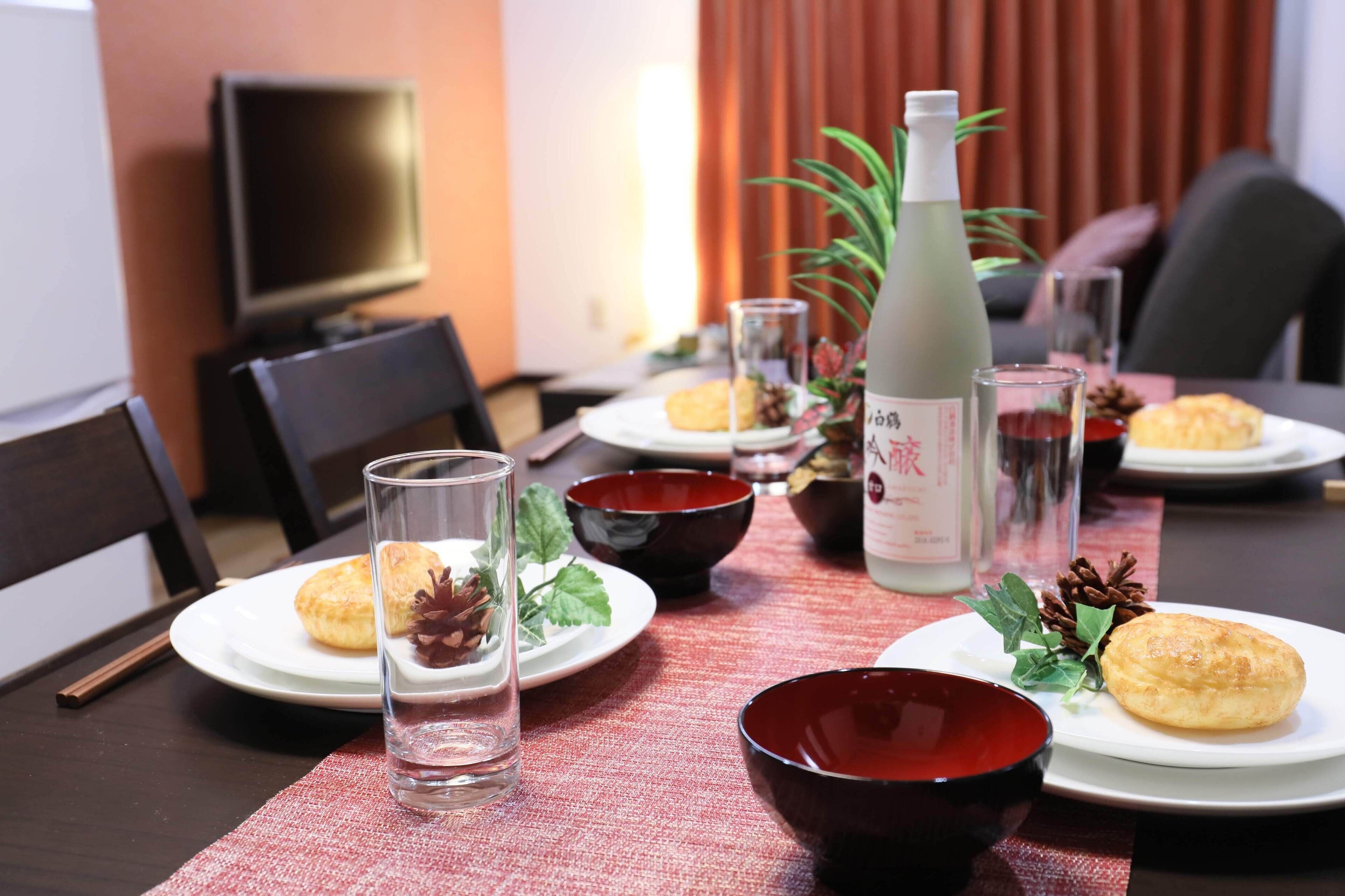 Uma mesa de jantar com pratos de comida, copos e uma garrafa de água.