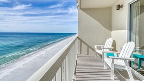 Un balcon avec vue sur la plage et l’océan.