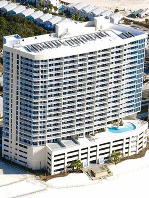 Un hôtel de grande hauteur, avec de nombreux étages, une cour intérieure et une piscine située sur le toit.