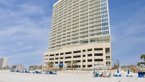 Un hotel moderno y alto, con varios balcones y ubicación frente a la playa.