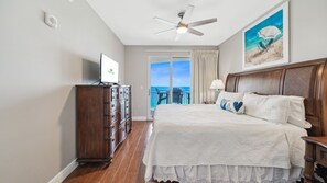 A bedroom with a bed, a dresser, a ceiling fan, a painting, and a view of the ocean through a sliding door. - *Oct 28 - Nov 5th open! * Beautiful condo! (Panama City Beach)