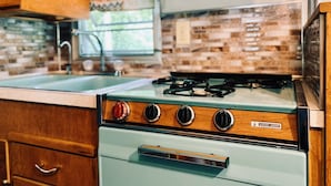 A kitchen with a vintage stove, wooden cabinets, and a tiled backsplash. - AGS Trailer House - Campground (Hakuba)