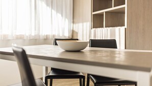 A dining table with a bowl, two chairs, and a television mounted on the wall. - Holiday Apartment "Dui Residenz Bun Sté" with Mountain View & Garden (San Vigilio di Marebbe)