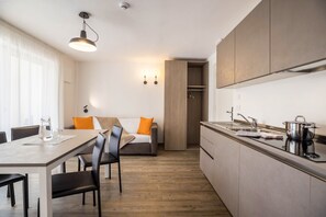 A modern kitchen with a dining area, wooden cabinets, and a built-in oven.