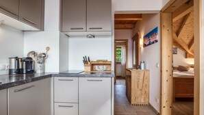 A modern kitchen with grey cabinets, a black countertop, and various kitchen utensils. - Holiday Apartment "Rosengarten - Wernerhof" with Mountain View, Wi-Fi, Balcony and Garden (Jenesien (BZ))
