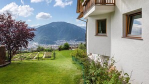 Talo, jossa on parveke, puutarha ja näkymä vuorille.