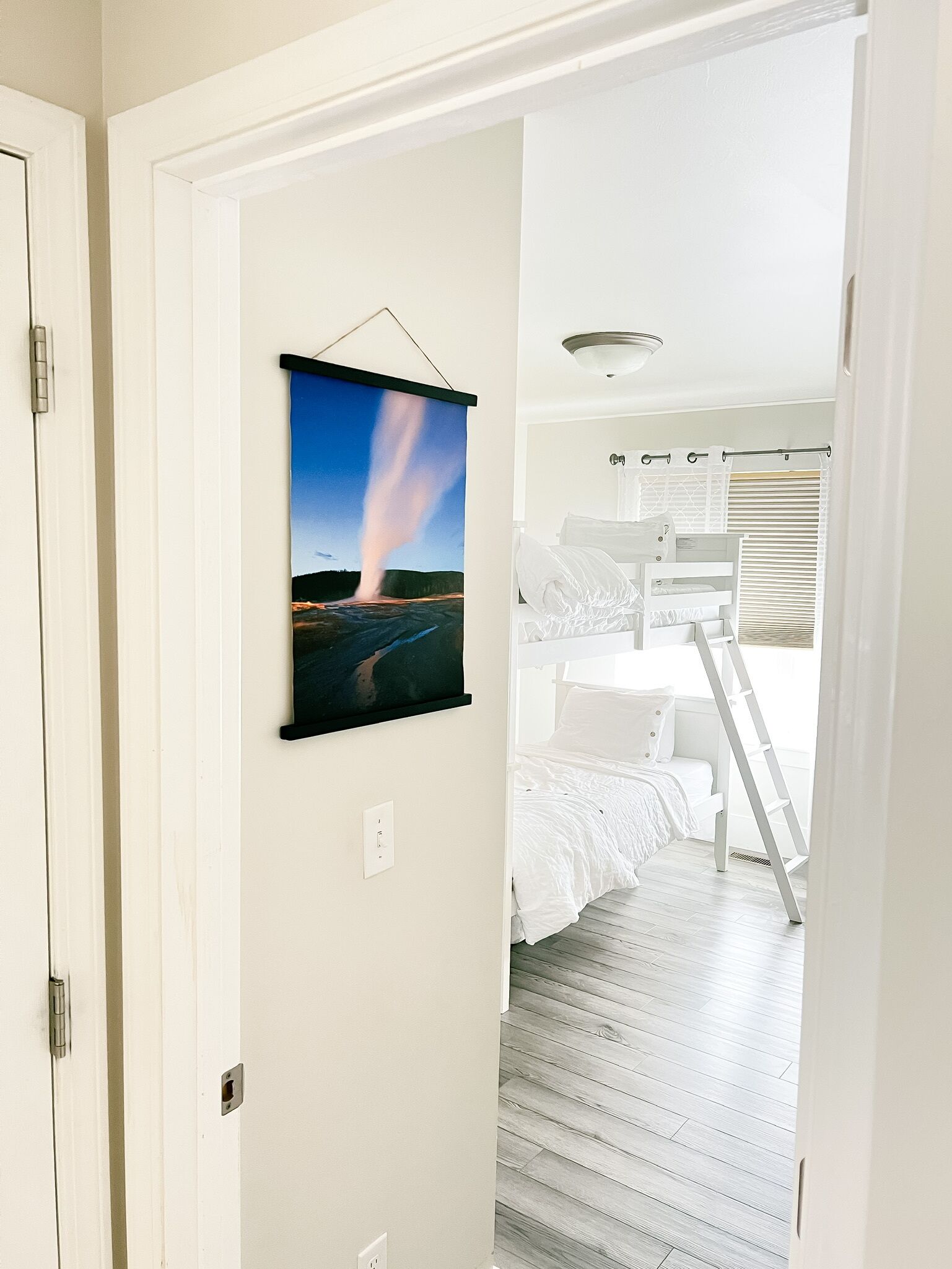 Ein Schlafzimmer mit einem Bett, einer Leiter und einem Blick auf eine Landschaft durch ein Fenster.