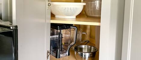 Una cocina compacta con horno empotrado, cafetera y microondas.