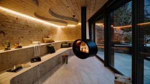 A modern interior with wooden paneling, a built-in fireplace, and a large window offering a view of the outdoors.