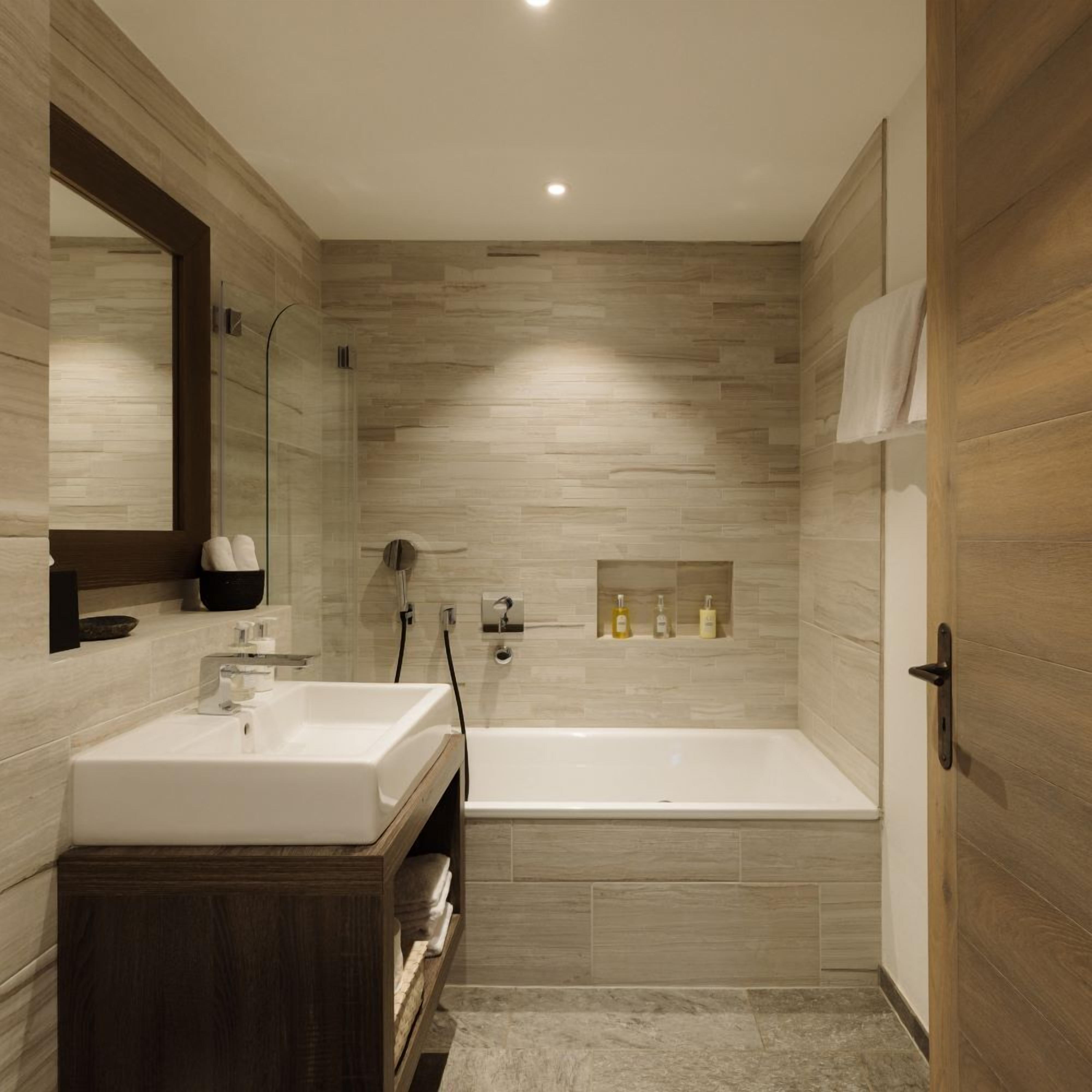 Un baño moderno con una bañera independiente, un tocador con espejo y una zona de ducha.