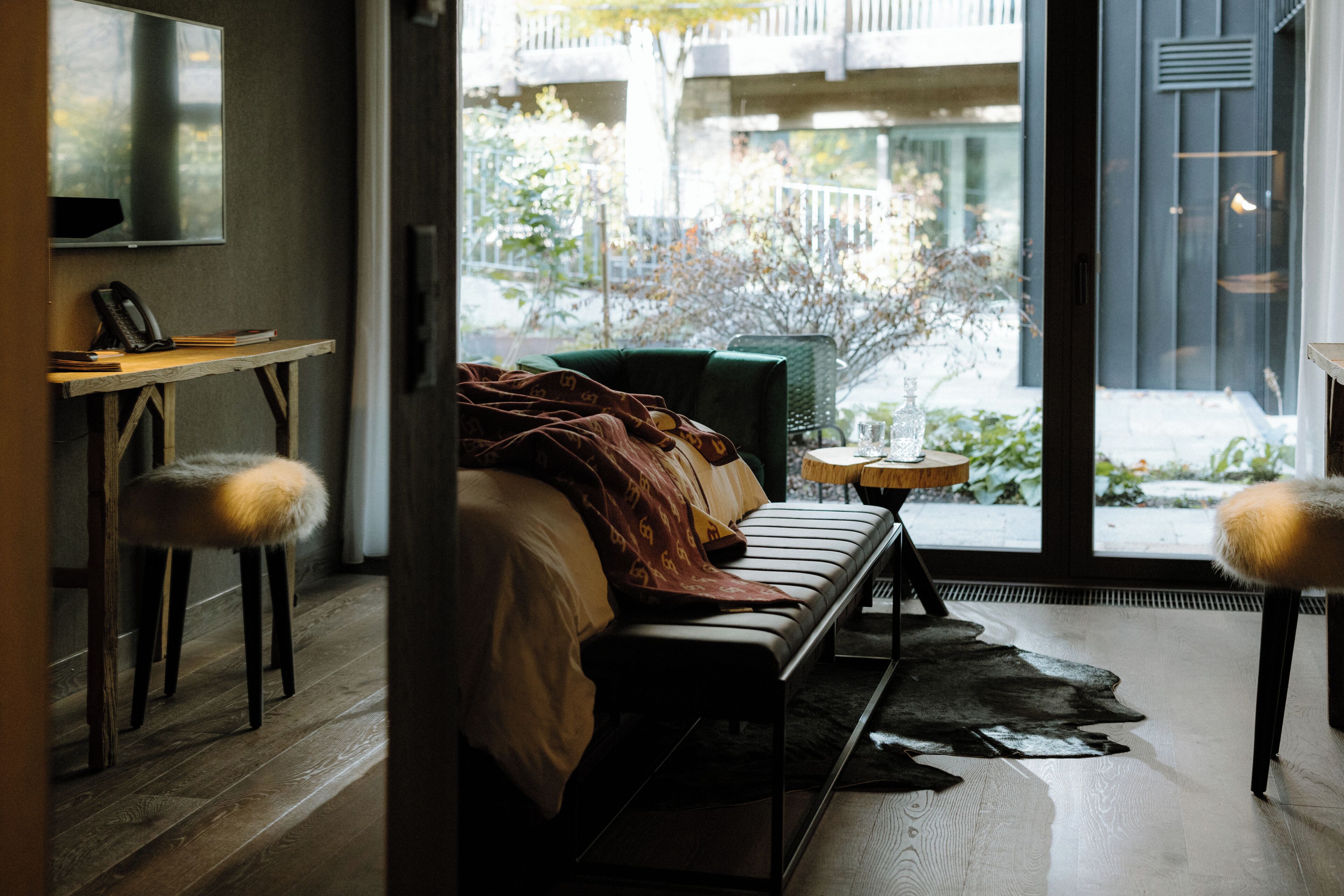 Un interior moderno con un sofá, una mesita redonda y una silla con reposabrazos mullidos.