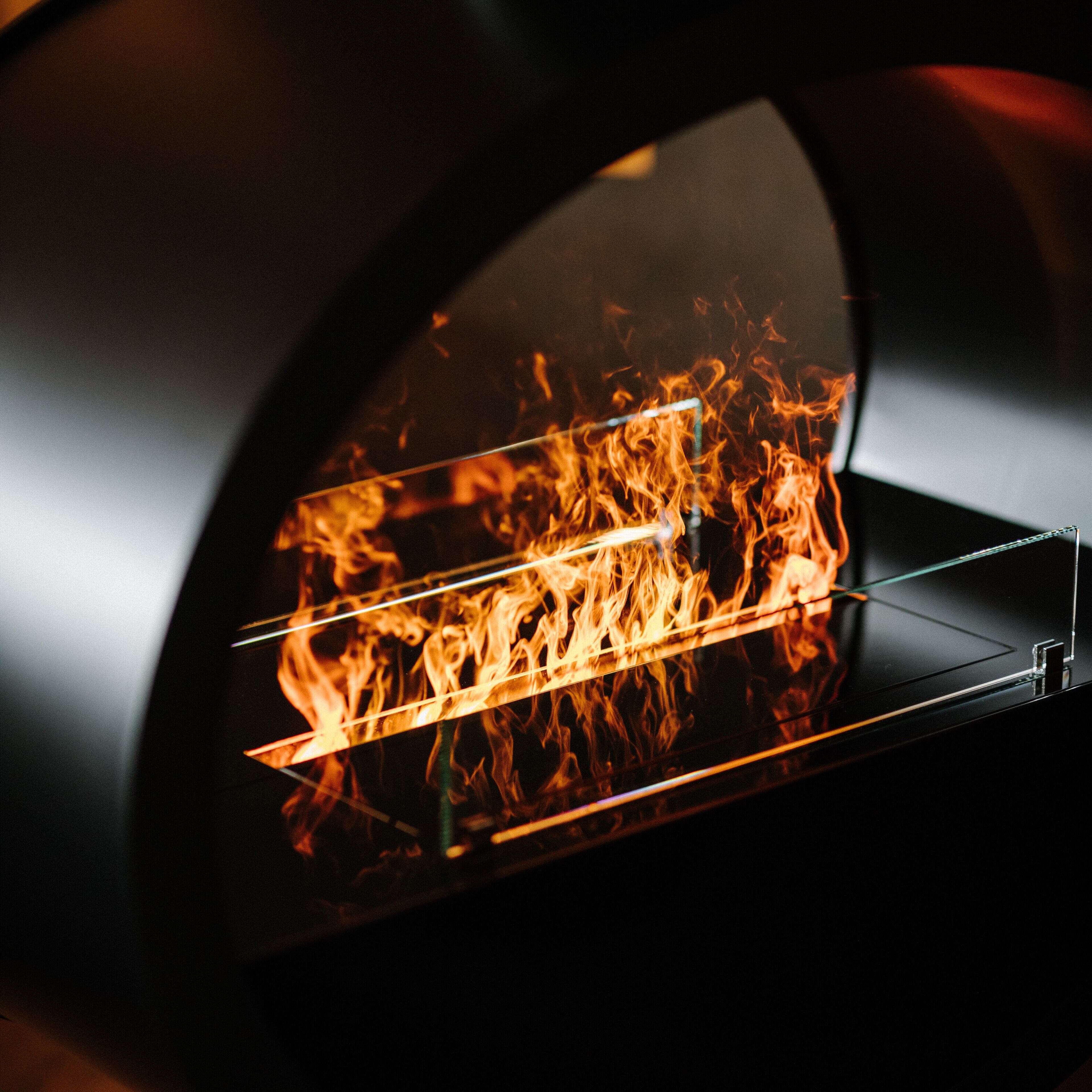 A close-up view of a wood-fired oven with visible flames inside.