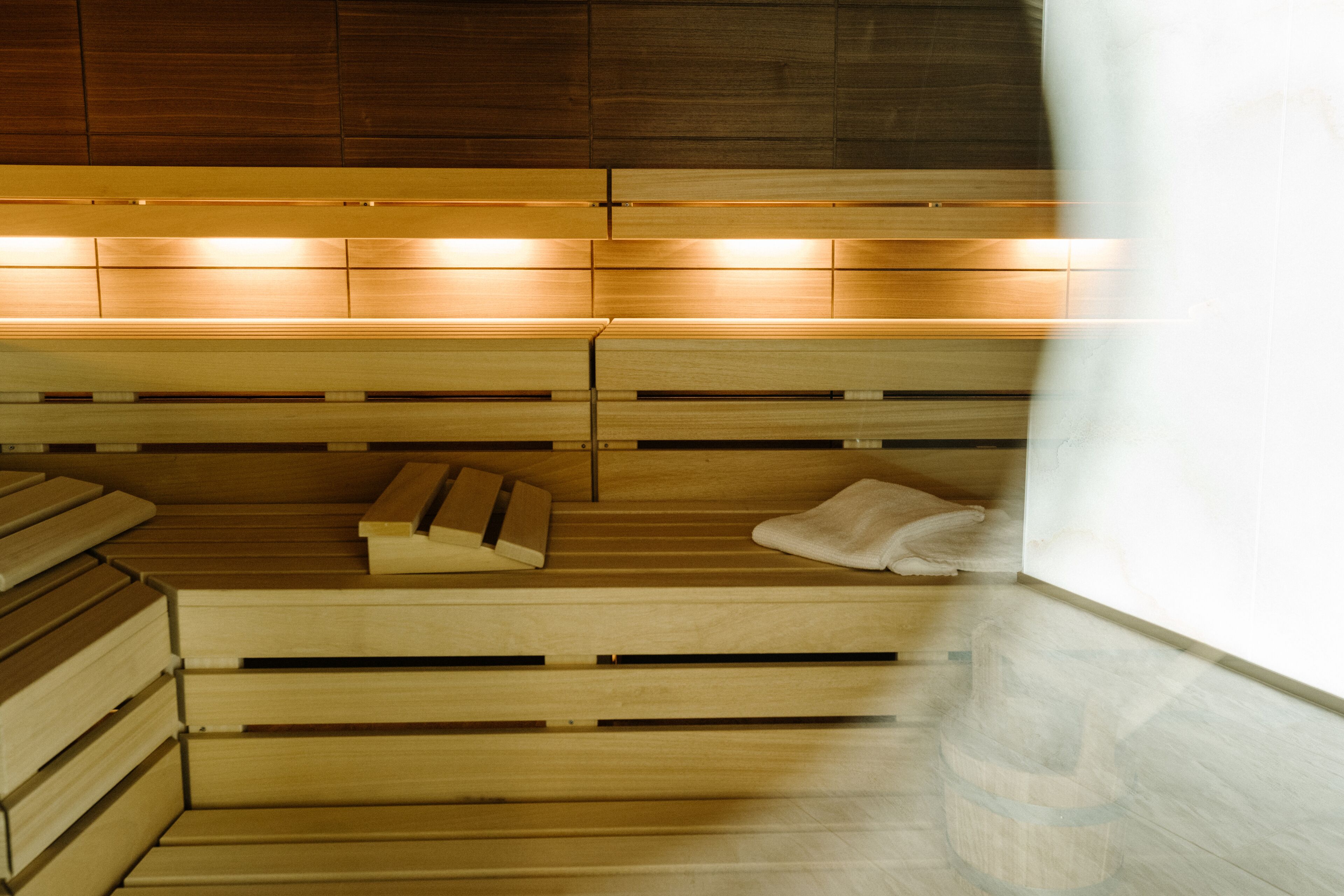 Una sauna con bancos de madera y una toalla sobre uno de ellos.