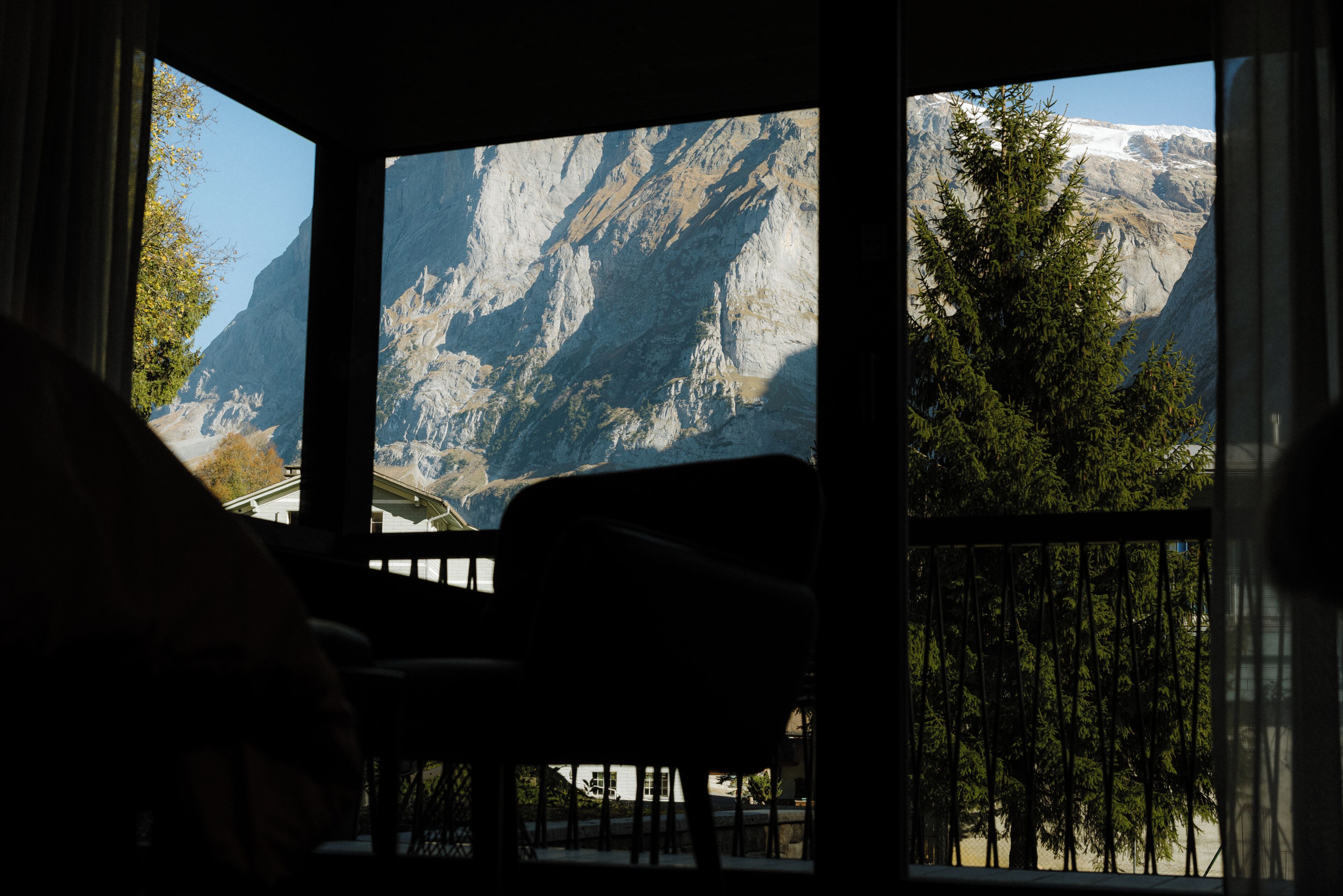 Ein Zimmer mit Blick auf Berge durch große Fenster.
